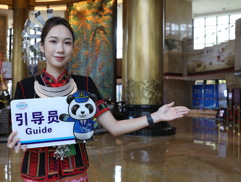 身穿黎族服装的引导员在论坛现场给来宾做引导